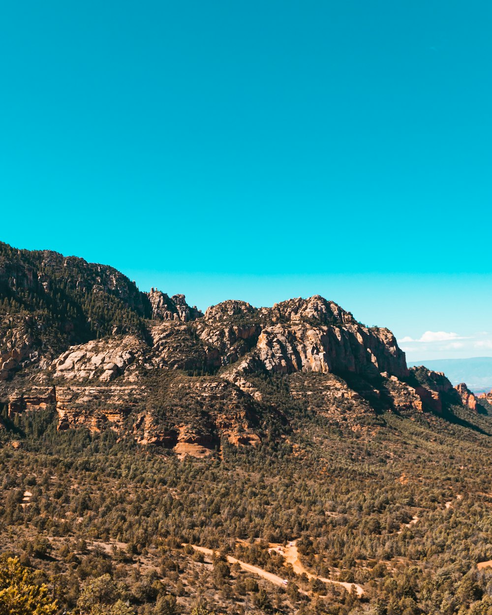a scenic view of a mountain range with a clear blue sky