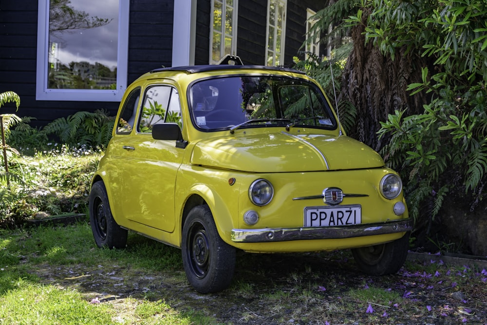 yellow volkswagen beetle parked on green grass field during daytime