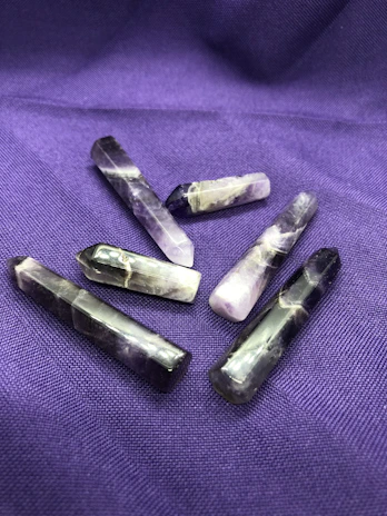 A vibrant cluster of polished amethyst stones displayed on a wooden table.