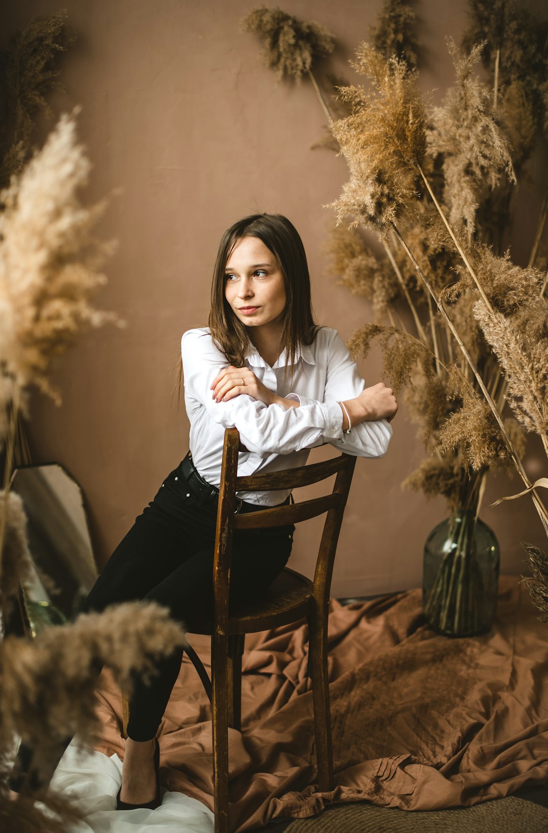 woman in white long sleeve shirt sitting on brown wooden chair