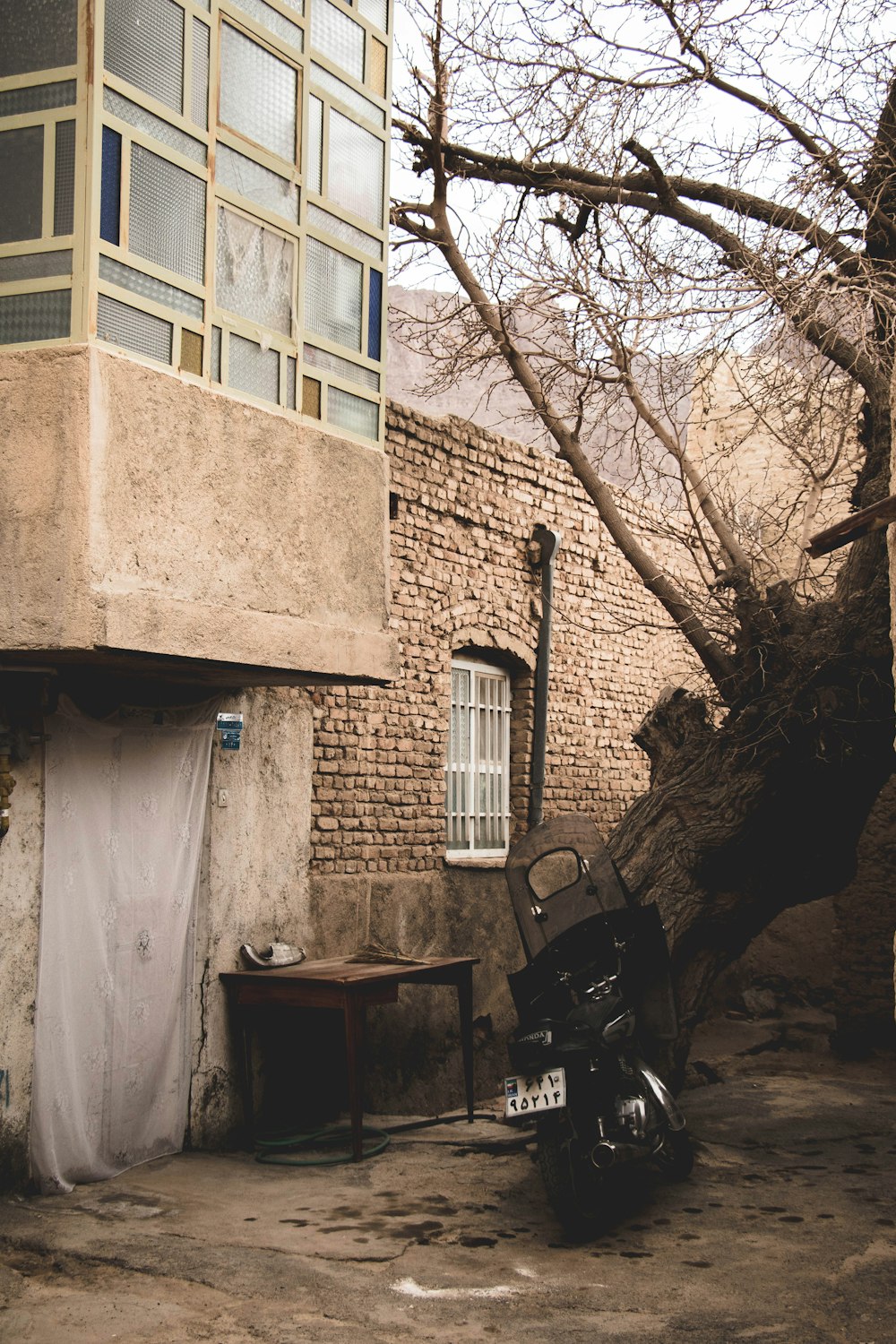 black motorcycle parked beside brown concrete building
