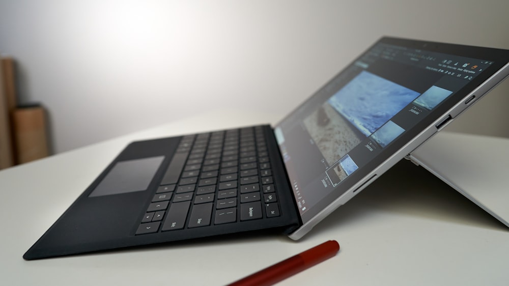 black laptop computer on white table