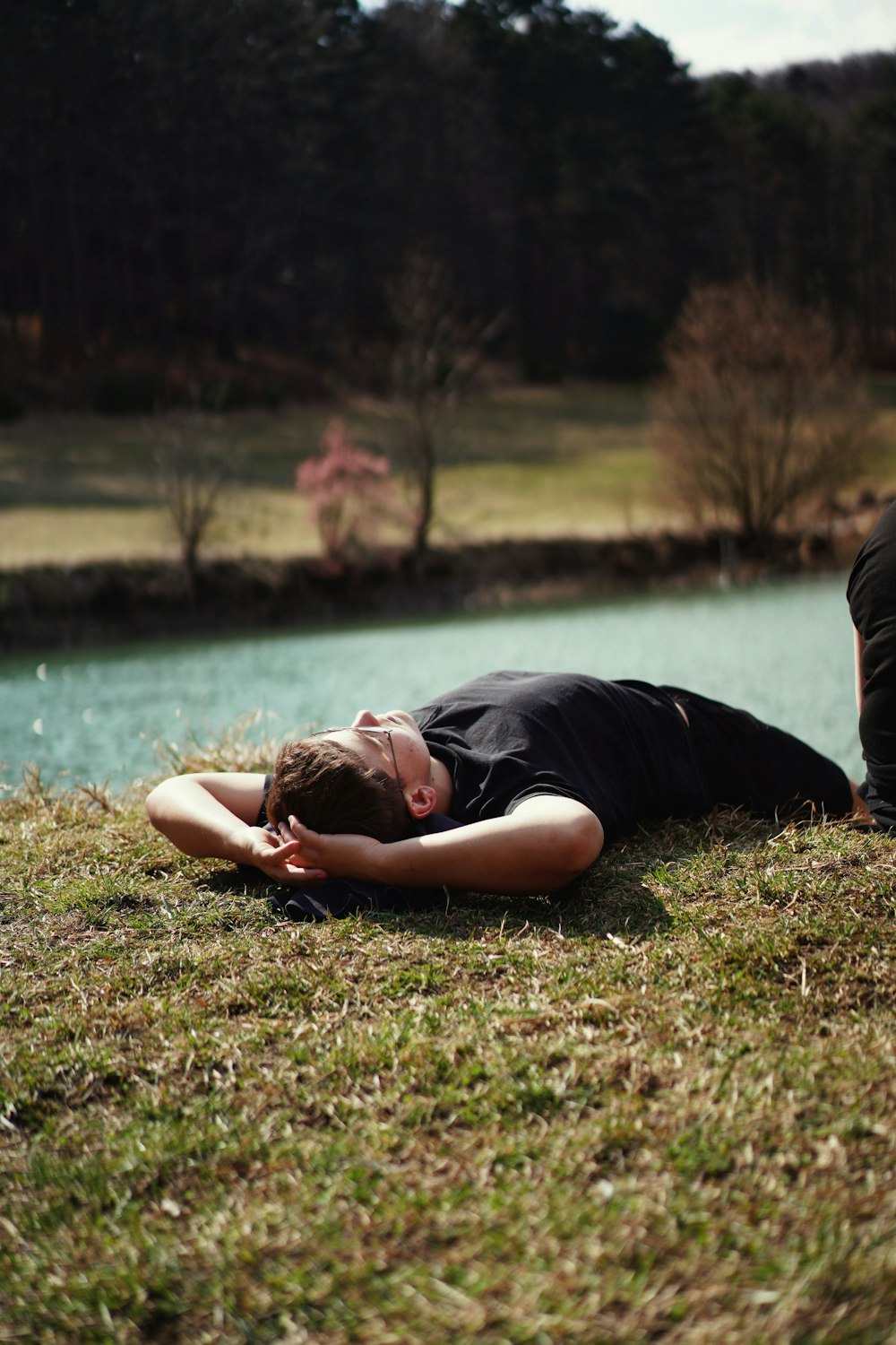 woman in black shirt lying on green grass field