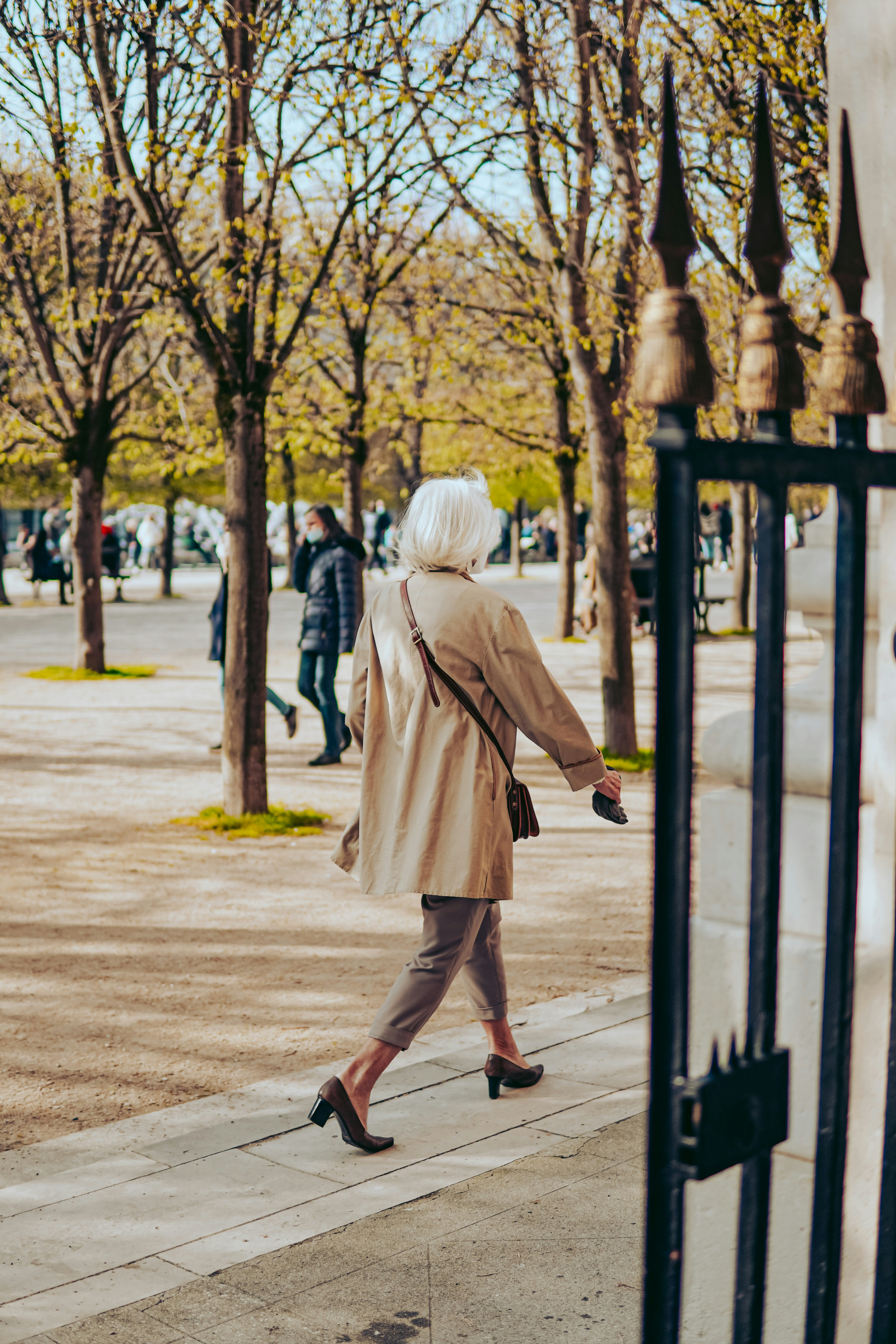 woman in brown coat walking on street during daytime