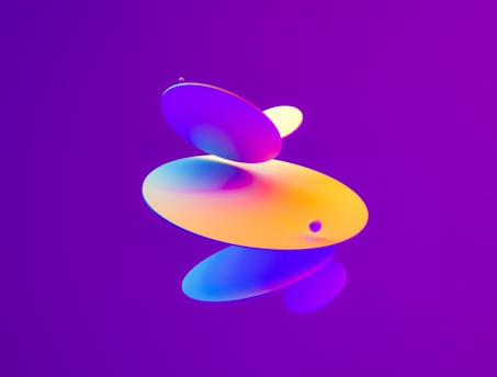 A series of colorful, rounded, overlapping geometric shapes float against a vibrant purple background. The shapes exhibit a gradient of colors, including shades of orange, yellow, blue, and pink.