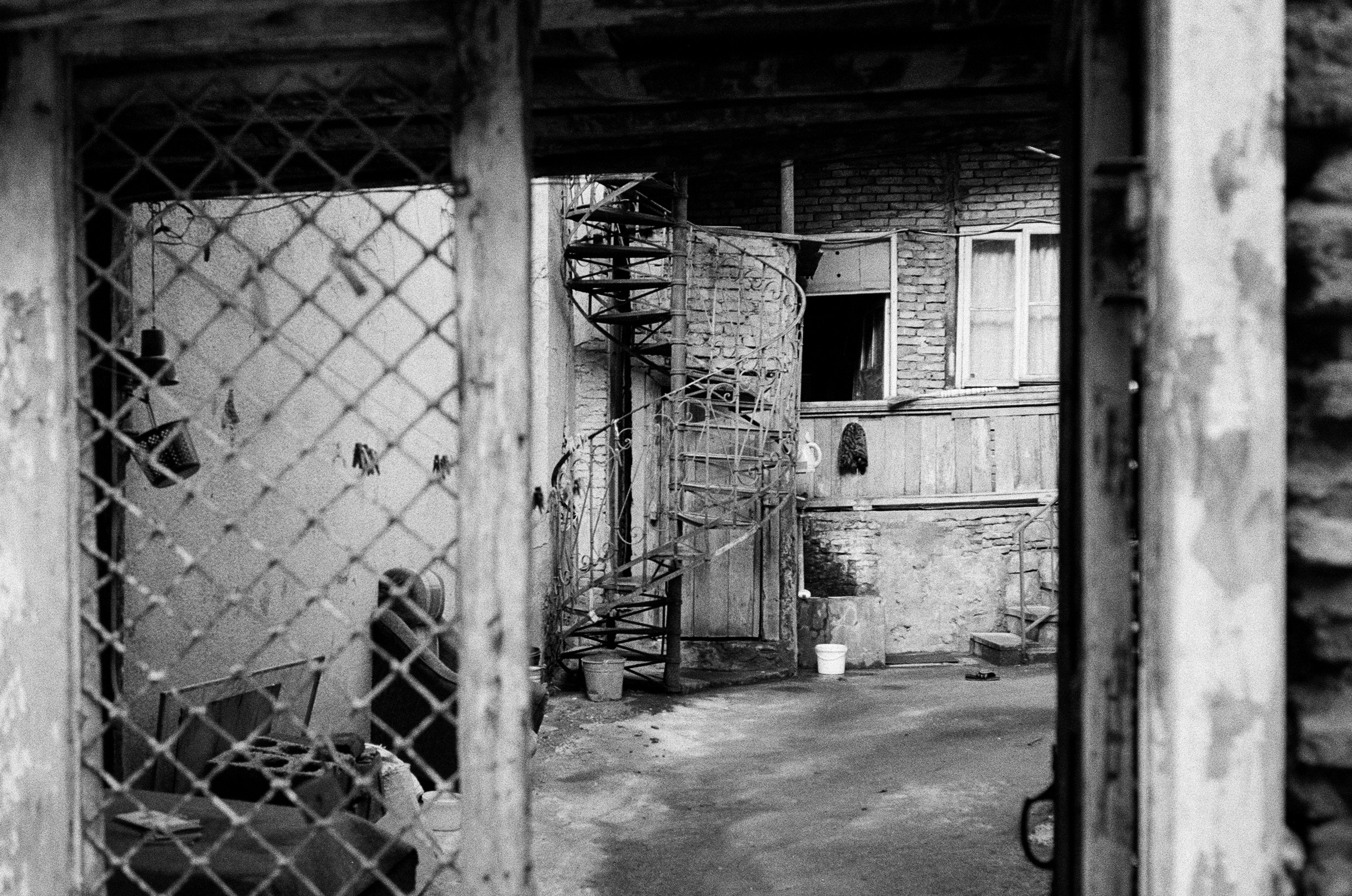 foto in scala di grigi della recinzione metallica