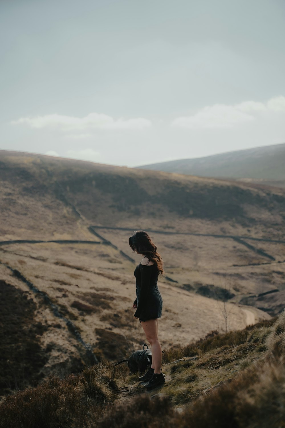 woman in black shirt standing on brown rock formation during daytime