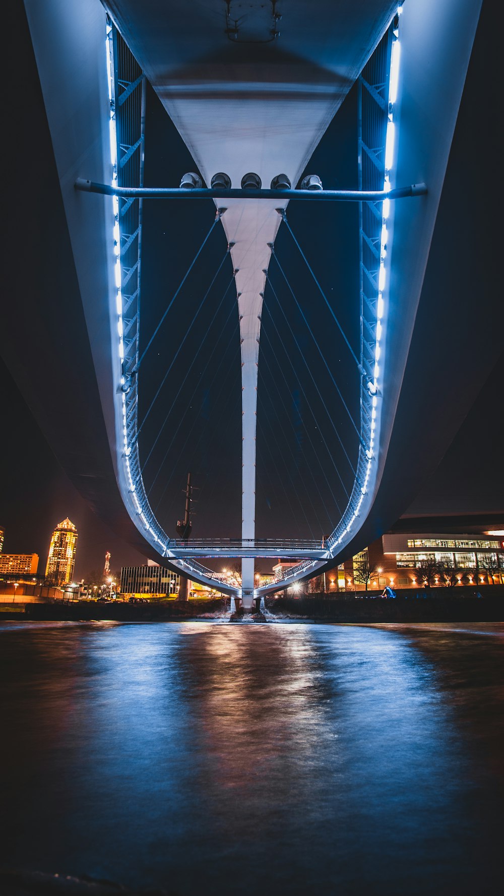 ponte azul sobre o corpo de água durante a noite