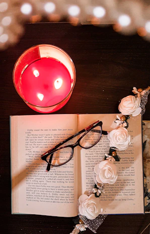 An open astrology book with a brass diya lamp casting a warm glow on the pages.