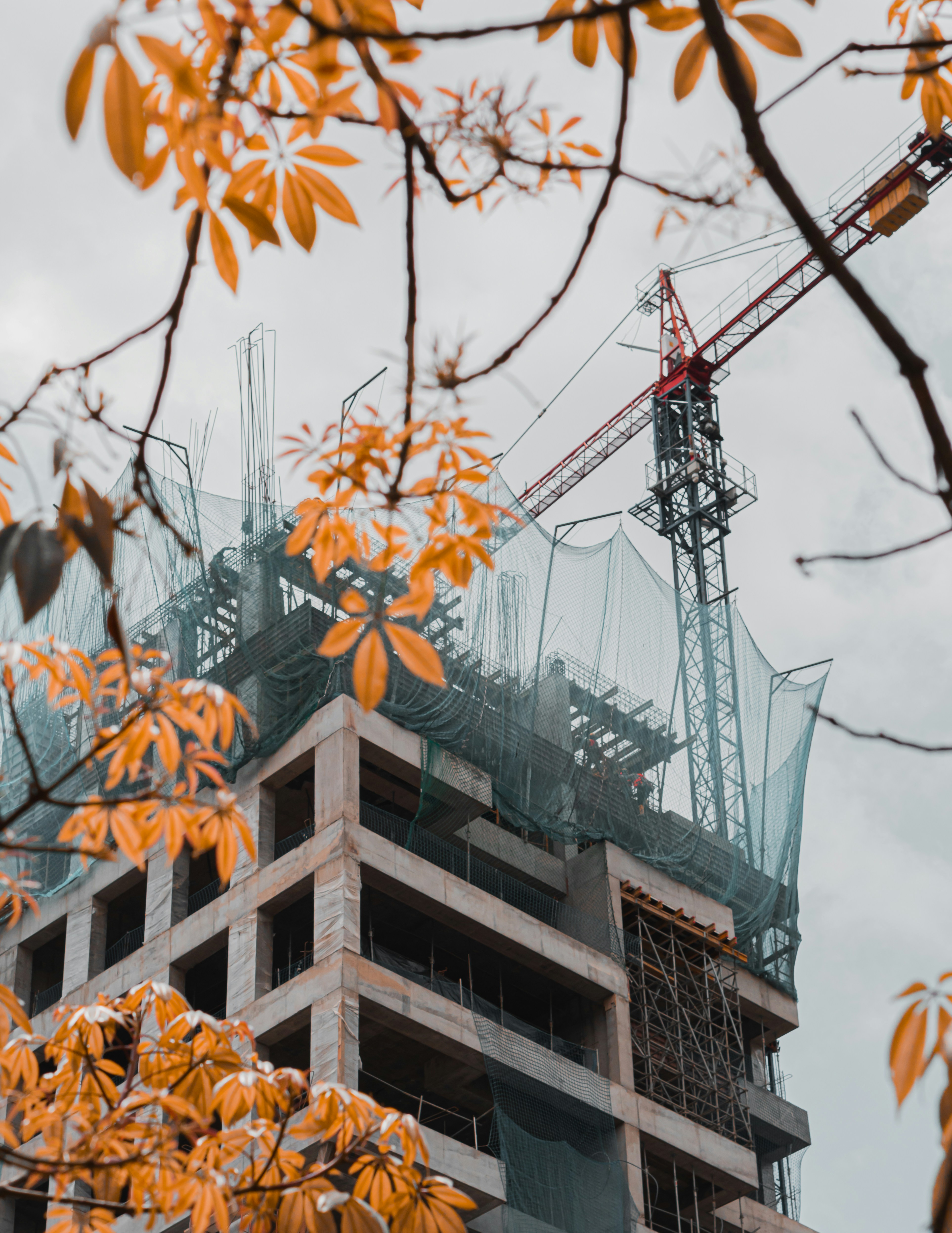 brown concrete building with red crane