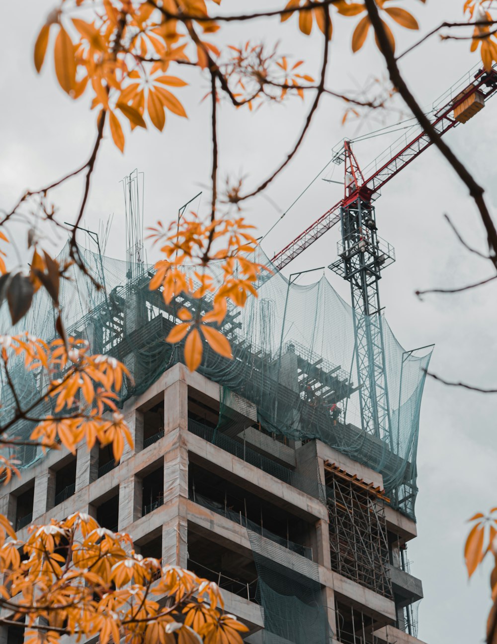 brown concrete building with red crane