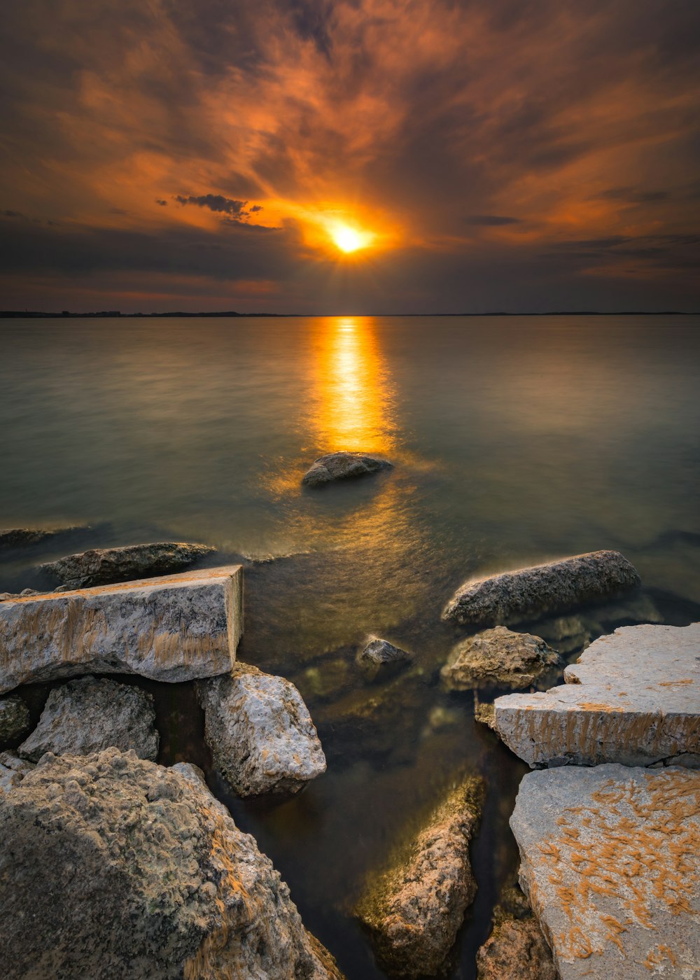 gray rocks on sea during sunset