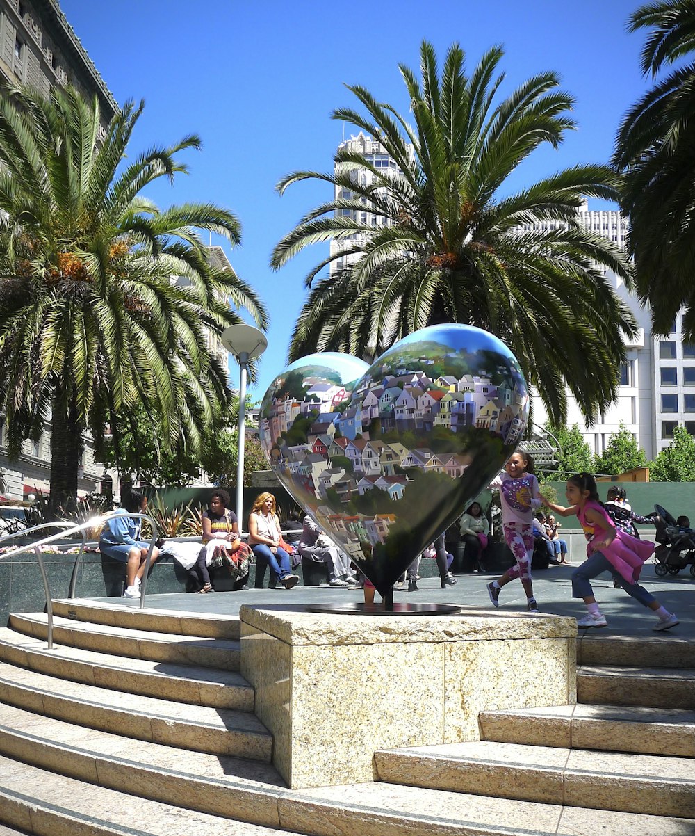 people sitting on stairs near green palm trees during daytime