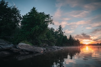 A tranquil getaway scene featuring a serene lake at sunset.
