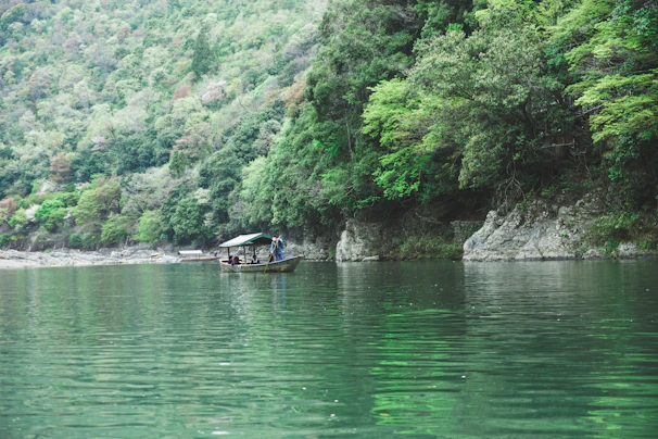 Travelers enjoying a peaceful boat ride on the Shipra River, framed by lush greenery.