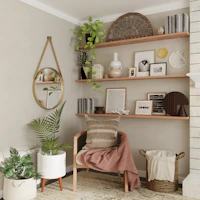 A cozy linen blend chair with soft cushions, placed beside a floating corner shelf filled with small plants and trinkets.
