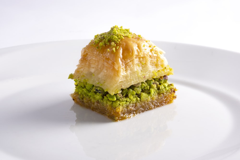 brown bread with green vegetable on white ceramic plate