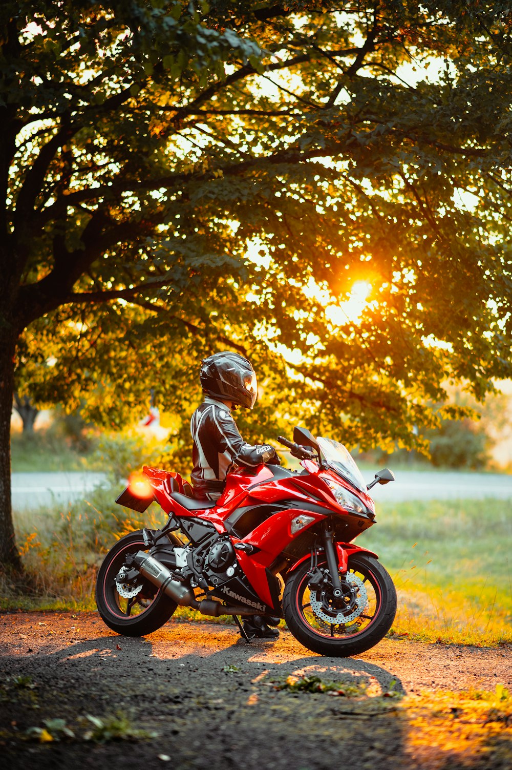 낮 동안 빨간색과 검은색 오토바이를 타고 빨간색과 검은색 오토바이 헬멧을 쓴 남자