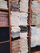 Neatly folded clean towels stacked on a shelf.