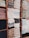 Neatly stacked towels in various colors are arranged on wooden shelves. The towels are folded and organized in columns, showcasing a variety of textures and shades.