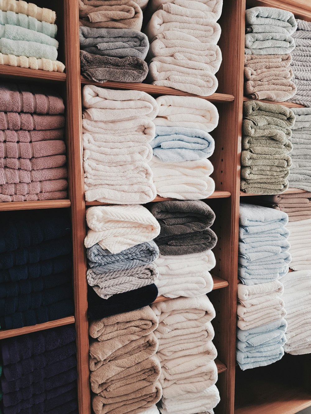 white and blue textile on brown wooden shelf