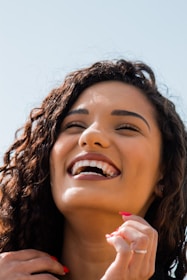 woman with brown hair smiling with white teeth