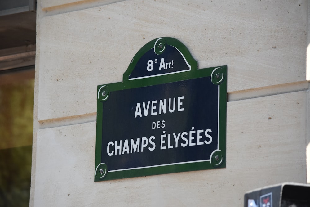 Un cartello sul lato di un edificio che dice Avenue des Champs Elysees