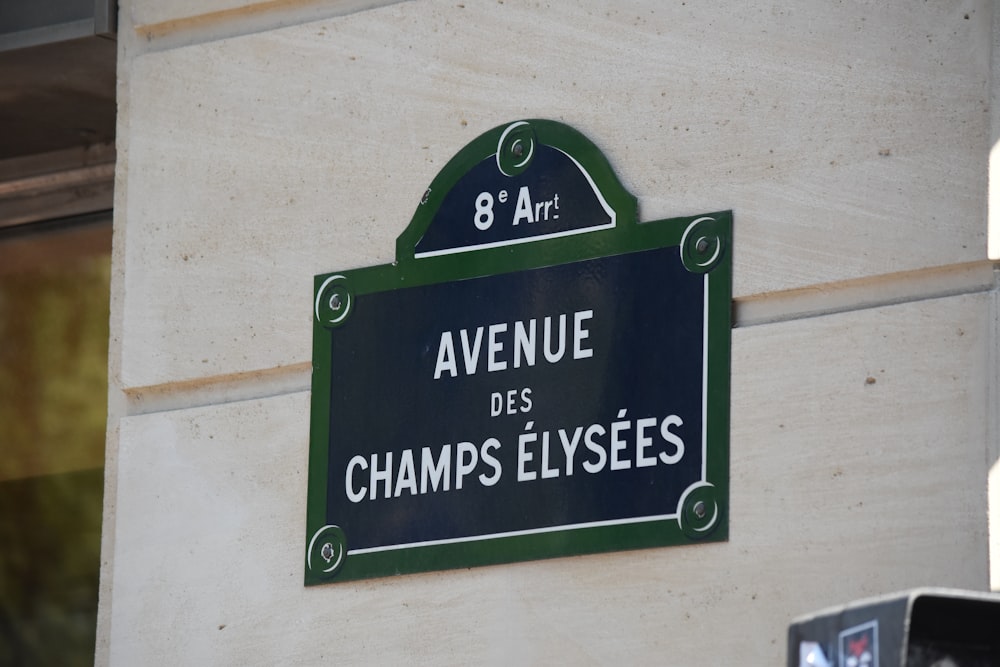 Un panneau sur le côté d’un immeuble qui dit Avenue des Champs Elysées