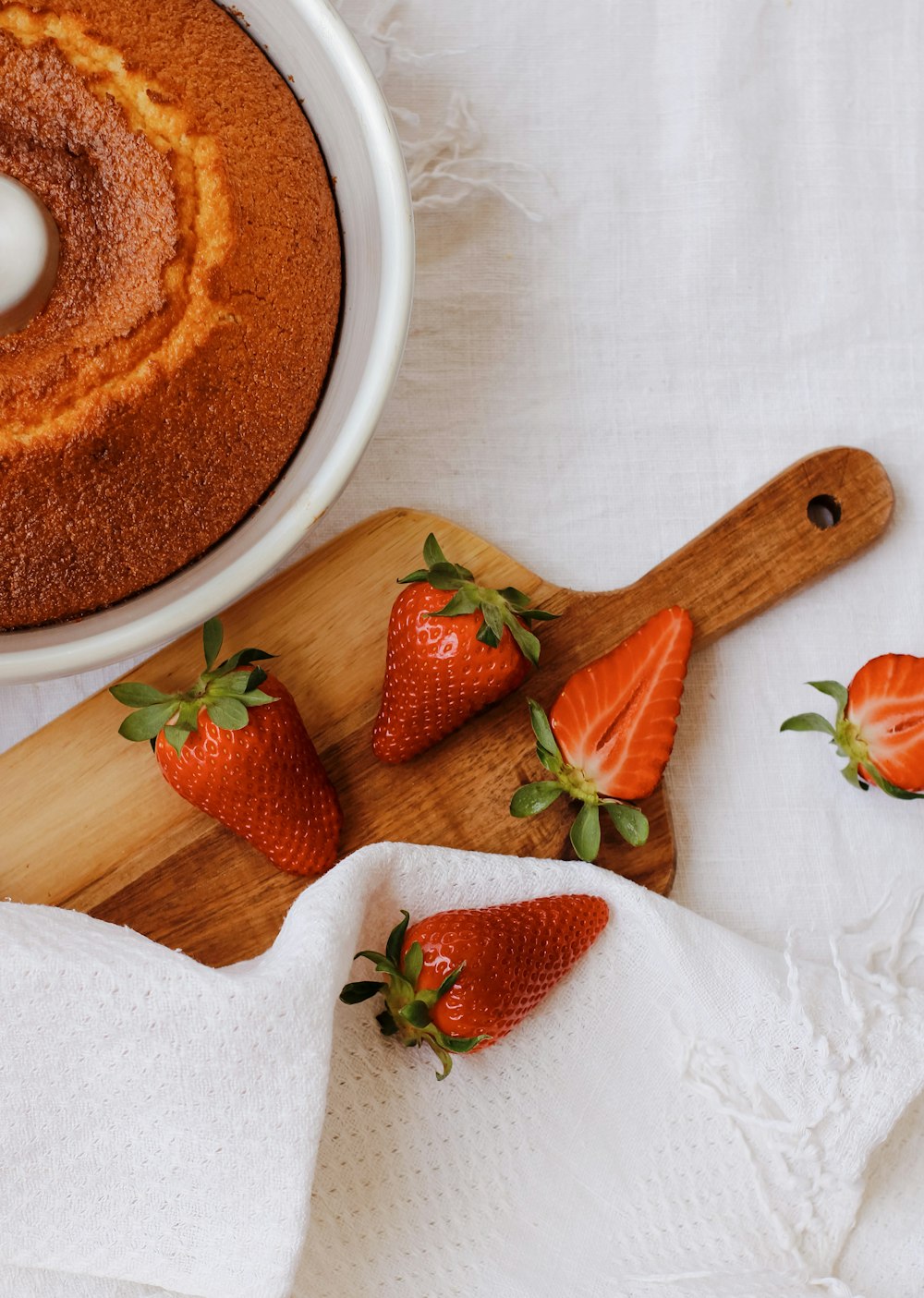 sliced strawberries on white ceramic bowl