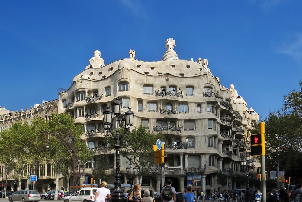 Personas caminando cerca de un edificio de hormigón blanco durante el día