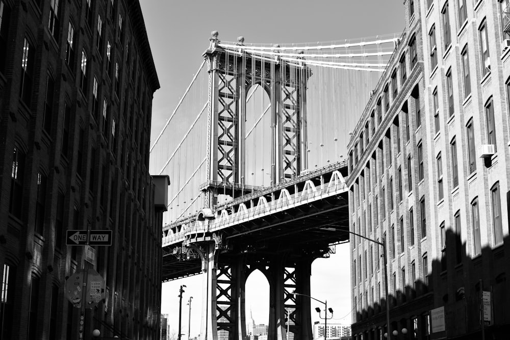 grayscale photo of bridge near buildings