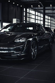 A sleek modern car parked in a bright showroom with large windows.
