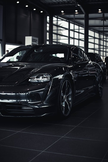 A sleek black luxury sedan gleaming under showroom lights in Onyx Motors.