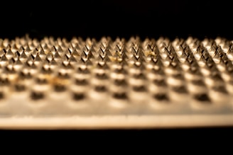 Modern metal grinder with sharp teeth, resting on a cracked ice background.