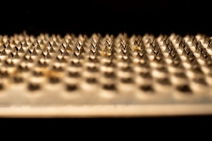 Modern metal grinder with sharp teeth, resting on a cracked ice background.