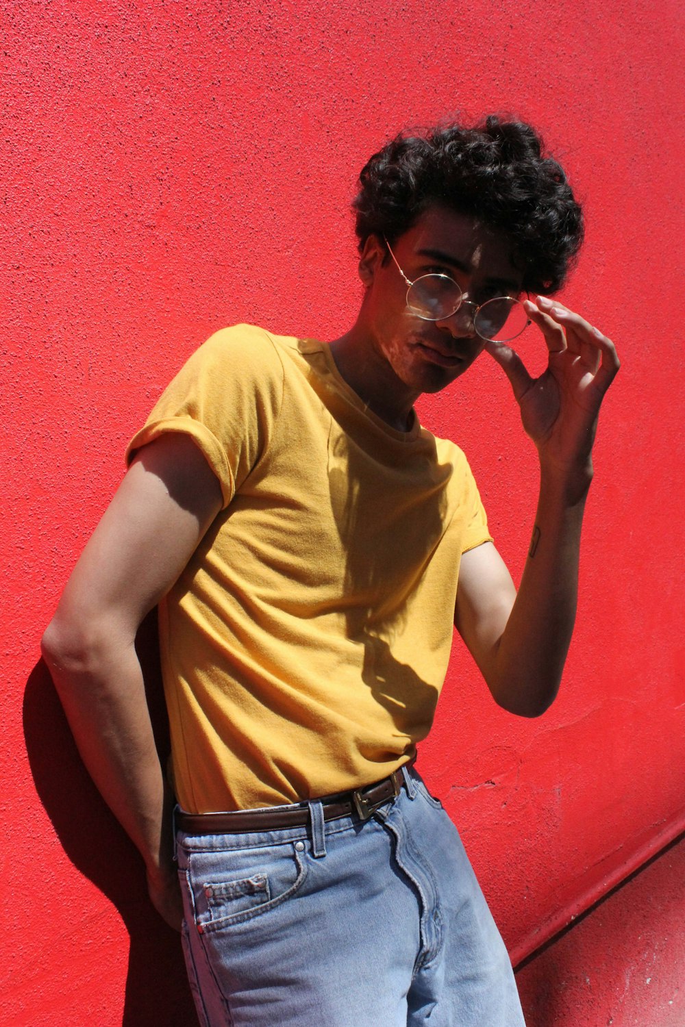 man in yellow crew neck t-shirt and blue denim jeans