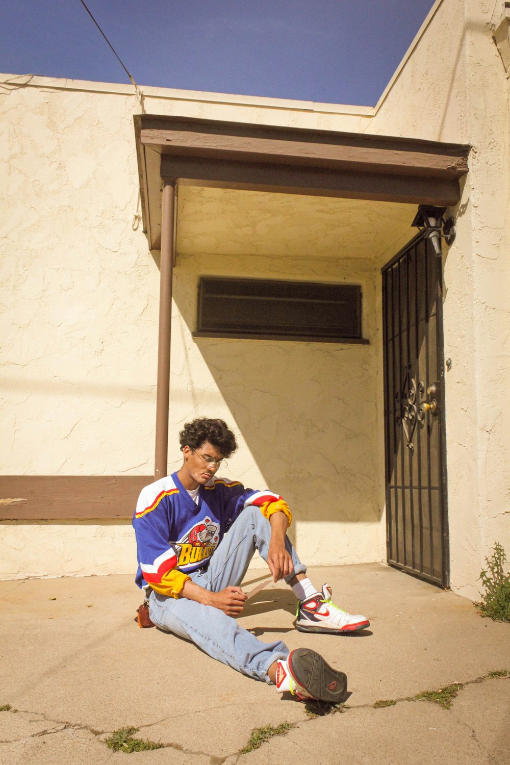 man in blue and white long sleeve shirt sitting on brown concrete stairs during daytime