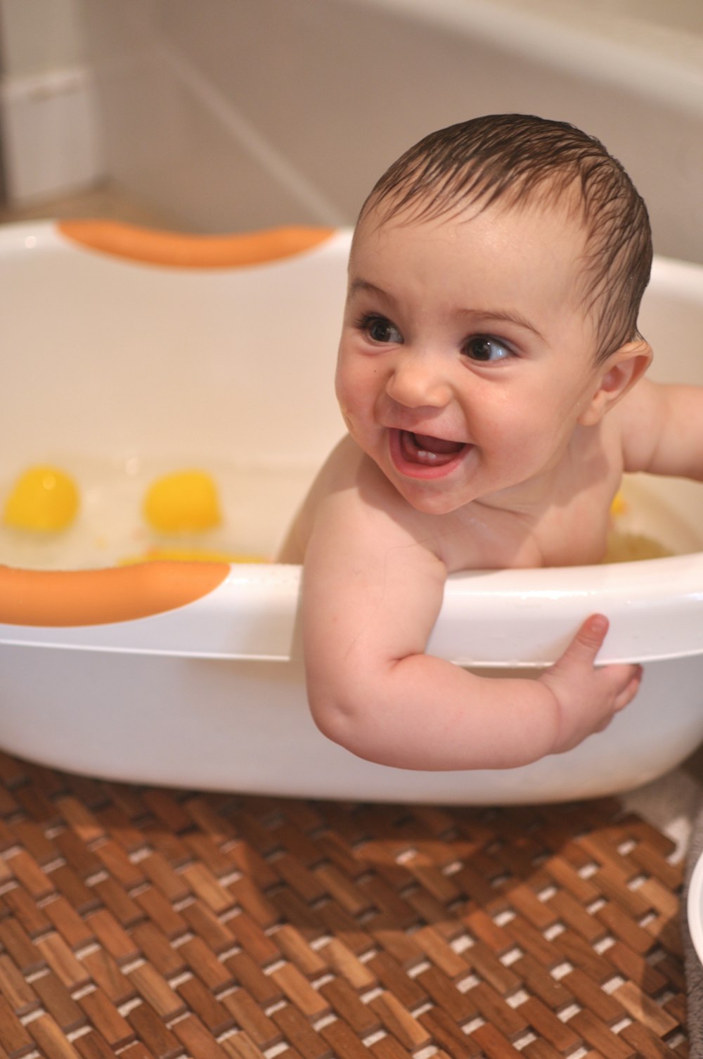 baby in white bathtub with yellow liquid