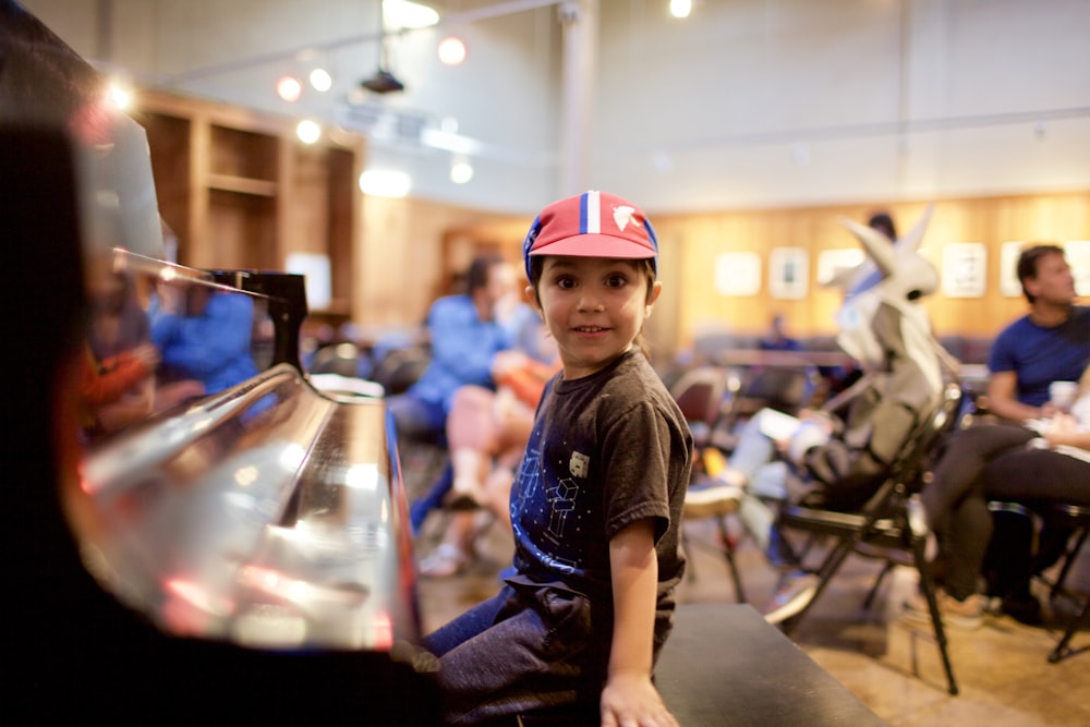 boy in blue and white crew neck t-shirt and red and white helmet