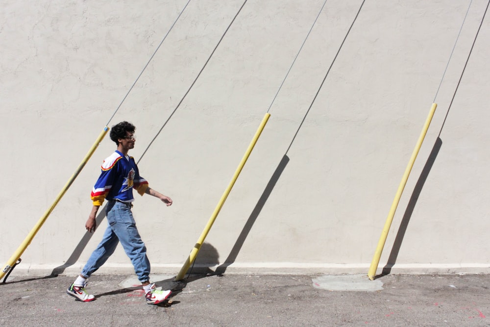 man in blue denim jeans and blue shirt holding yellow and black stick