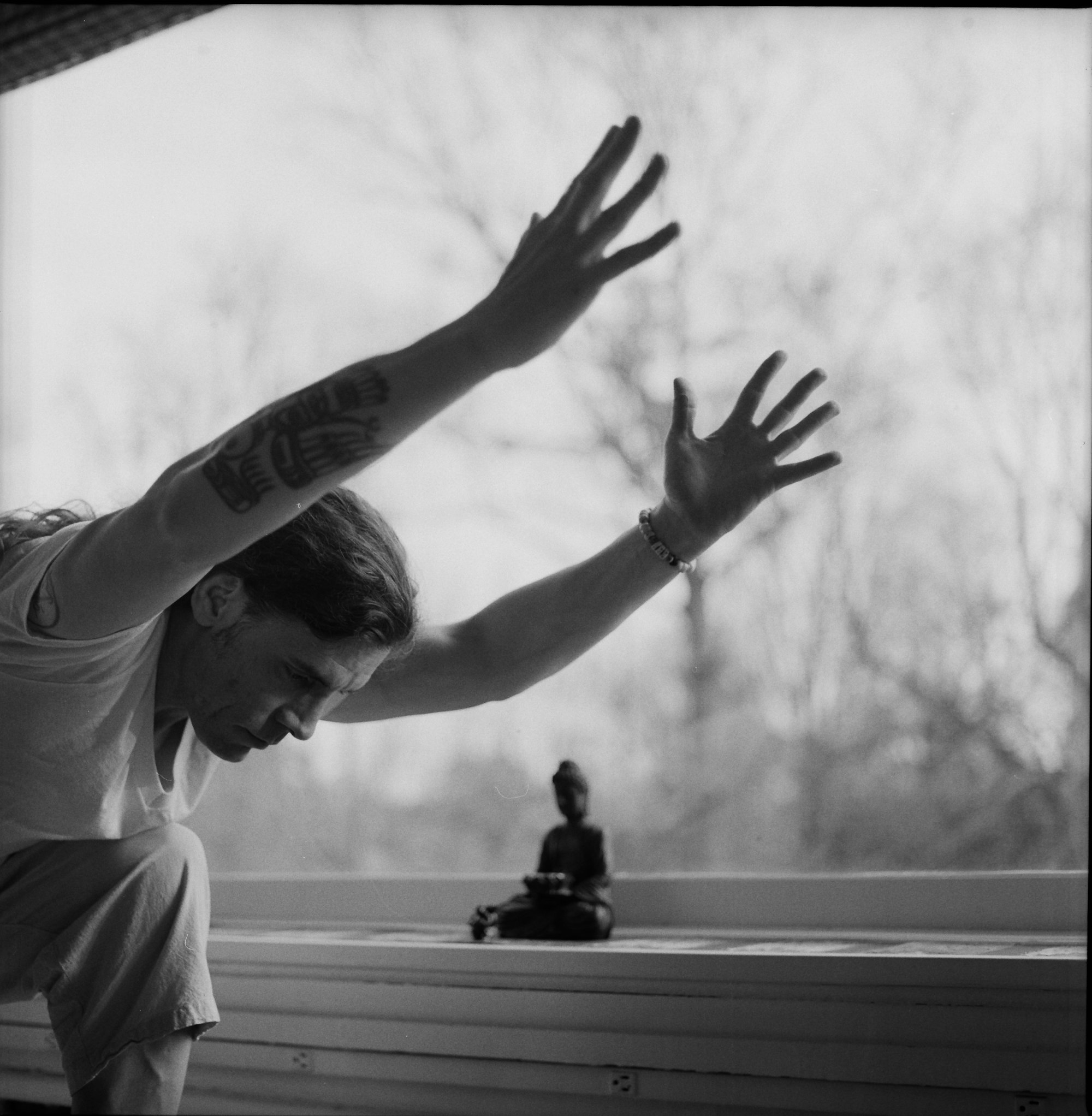 grayscale photo of woman in crew neck t-shirt raising her hands