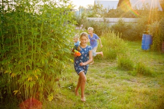 girl in blue and white shirt standing on green grass field during daytime
