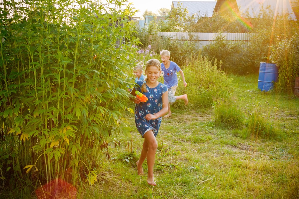 girl in blue and white shirt standing on green grass field during daytime