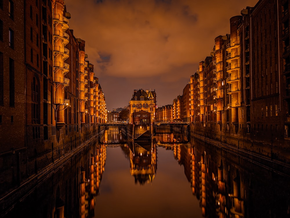 Reflexion des braunen Betongebäudes auf dem Wasser während der Nachtzeit