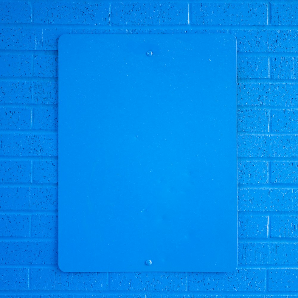 blue ipad on purple brick wall