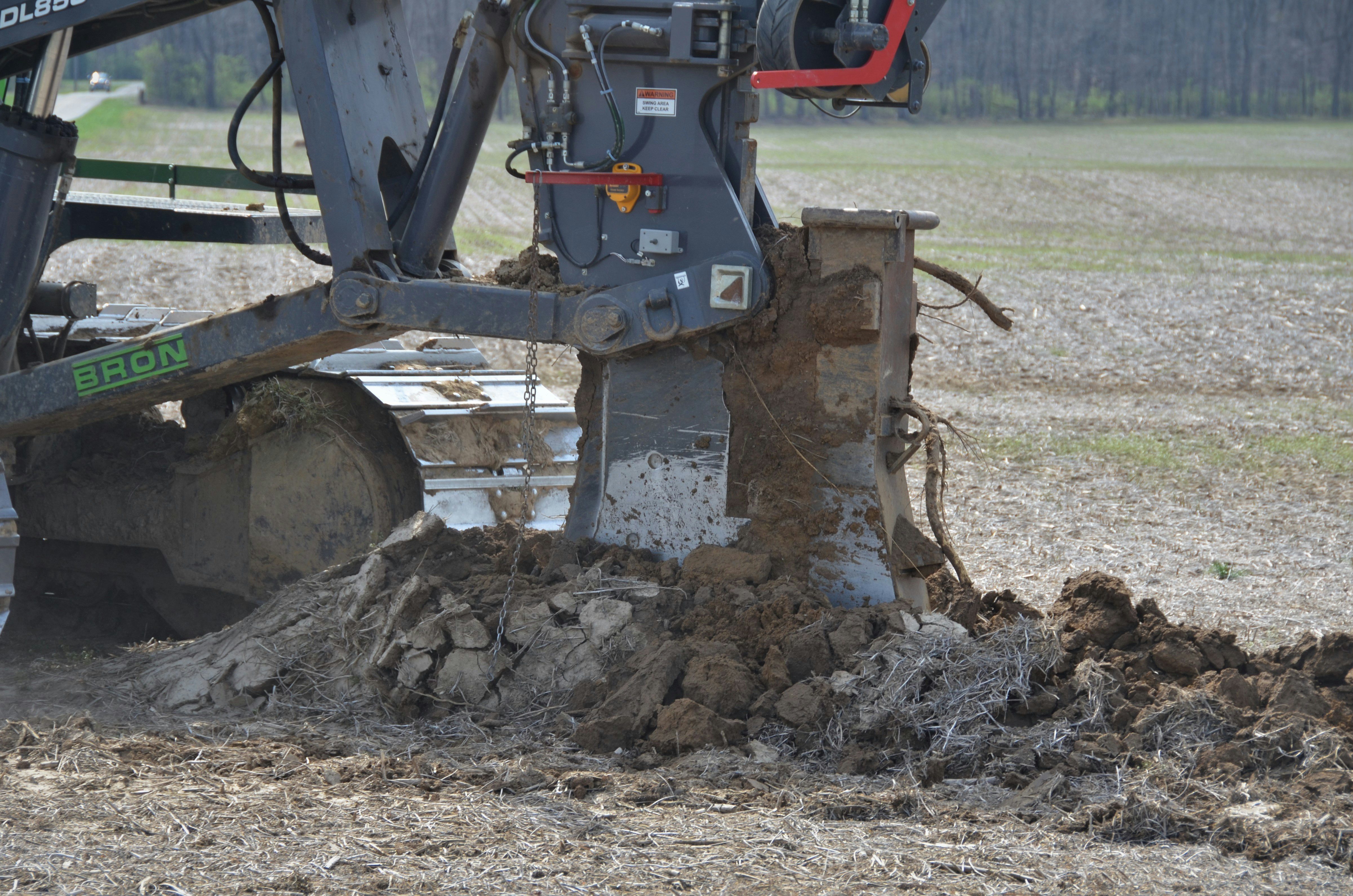 Bron 585 plowing in drain tile in farm field