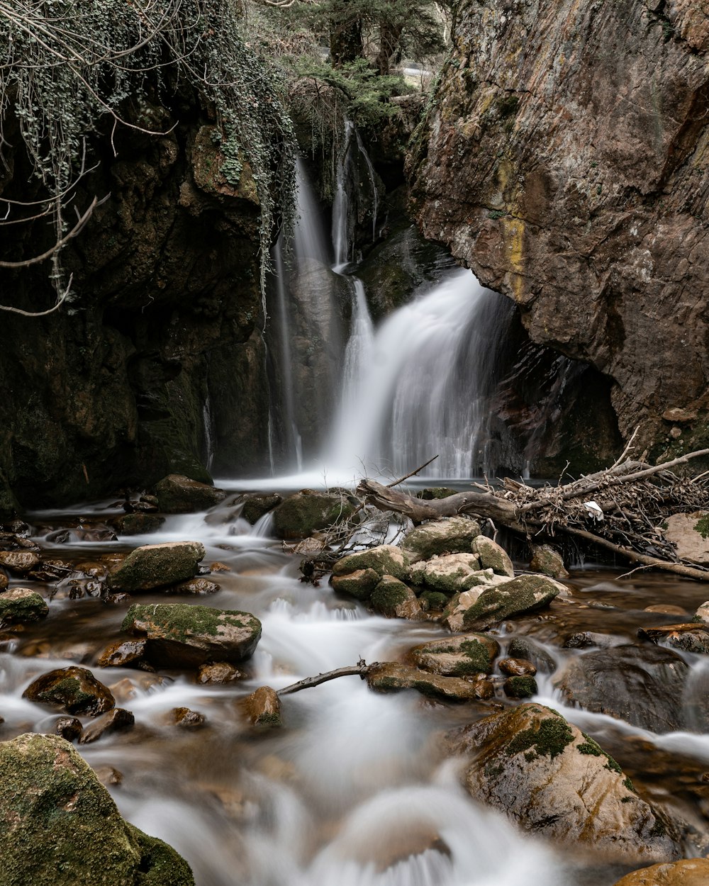 water falls between brown rocks