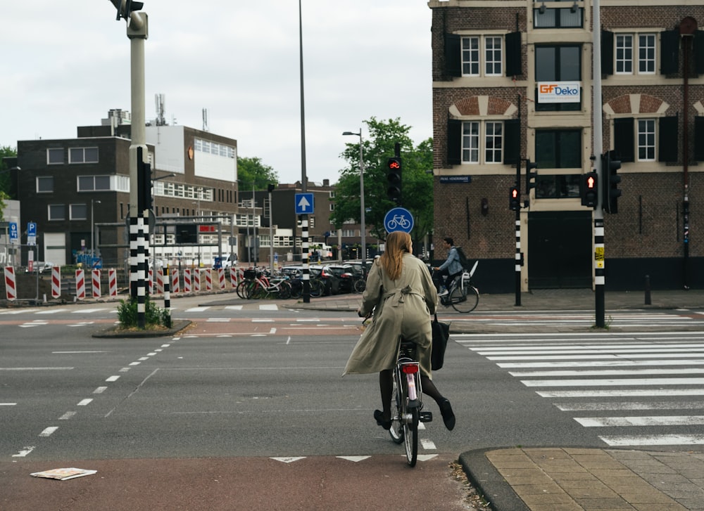 man in brown jacket riding bicycle on road during daytime