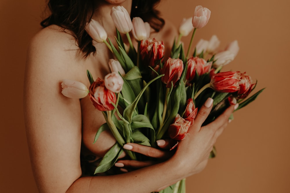woman holding red and white tulips