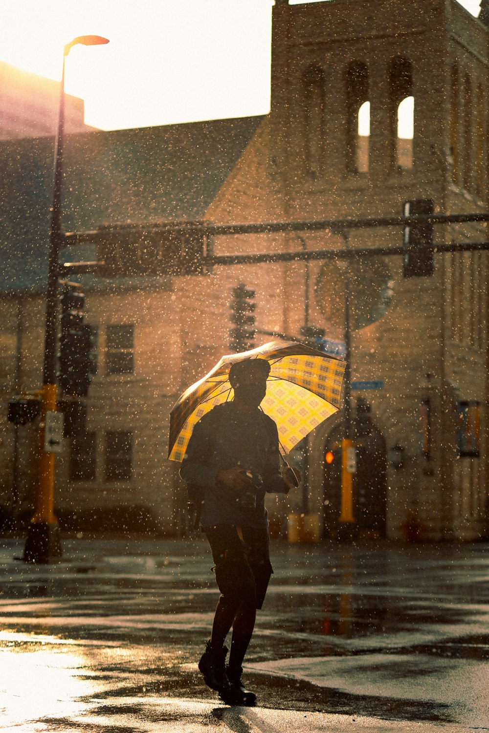 雨の中、傘をさして通りを歩く黒いジャケットを着た人物